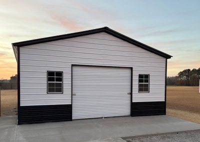 Black and white steel garage matching a farmhouse