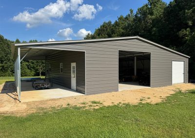 Grey metal garage with attached lean-to carport
