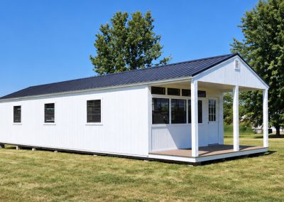 Portable cabin with metal roof and rocking chairs on porch